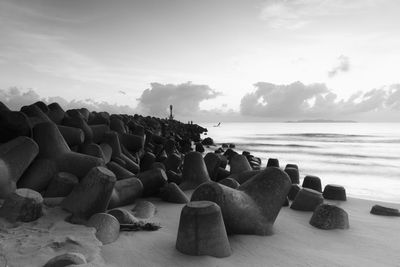 Groynes by sea against sky