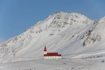 Built structure on snowcapped mountain against sky