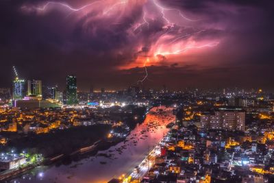 High angle view of illuminated city against sky at night