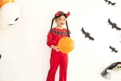 Full length of woman with red balloons