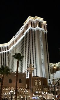 Low angle view of illuminated building against sky at night