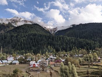 Panoramic view of houses and trees against sky