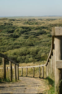 Wooden post in field against clear sky