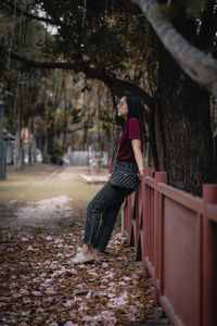 Side view of woman standing in forest