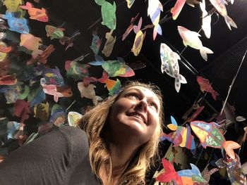 Low angle view of smiling woman looking at colorful decorations