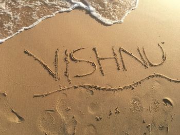 High angle view of vishnu text on shore at beach