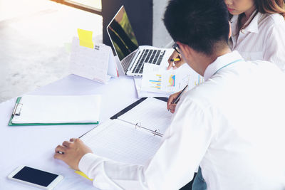 High angle view of people using laptop on table