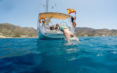 Man in boat on sea against clear sky