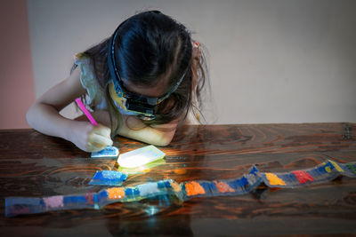 Side view of girl playing with toys on table