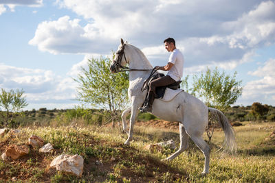 Man riding cart on land against sky