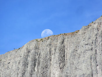 Low angle view of mountain against blue sky