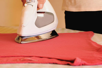 Cropped image person ironing cloth