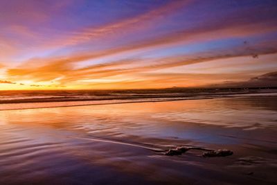 Scenic view of beach against sky during sunset