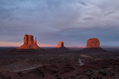 Rock formations at monument valley against cloudy sky