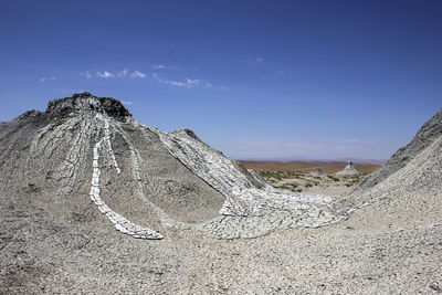 Scenic view of desert against blue sky