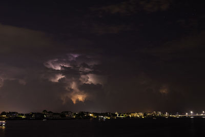 Illuminated city against sky at night