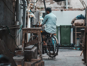 Rear view of man working on street in city