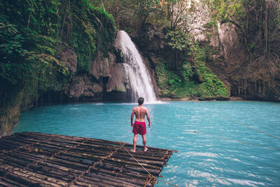 Man looking waterfall in forest