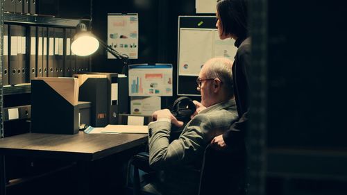Side view of woman using mobile phone while sitting at airport