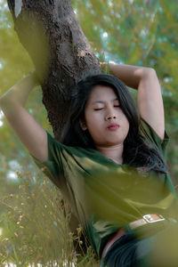 Young woman sleeping by tree