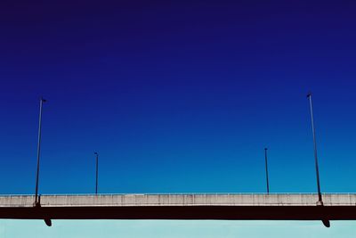 Low angle view of bridge against clear blue sky