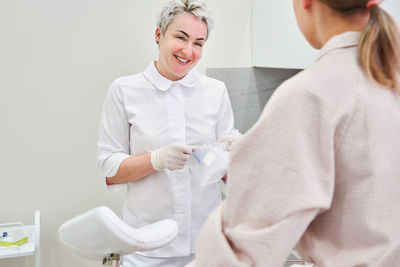 Smiling nurse talking with patient at clinic