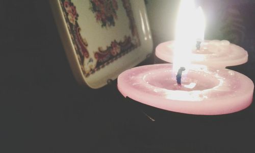 Close-up of lit candle in dark room