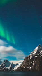 Scenic view of snowcapped mountains against sky at night