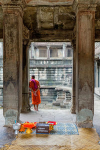 Rear view of monk standing in temple