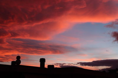 Low angle view of silhouette building against dramatic sky