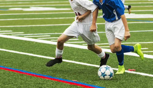 Low section of people relaxing on soccer field