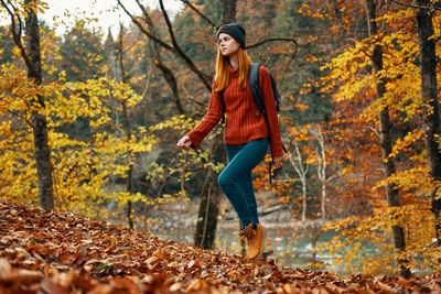 Full length of young woman in autumn leaves