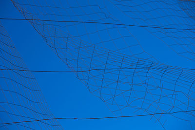 Low angle view of cables against clear blue sky