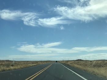 Road passing through landscape against sky