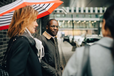 Rear view of people standing in city