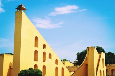 Low angle view of yellow building against sky