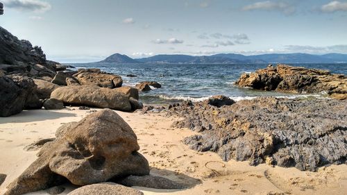 Rocks on beach against sky