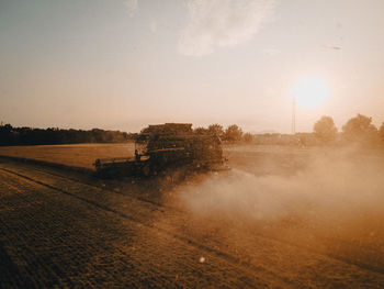 Scenic view of agricultural field against sky during sunset