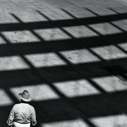 High angle view of man standing by shadow on walkway