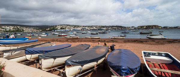 Panoramic view of boats moored on beach against sky