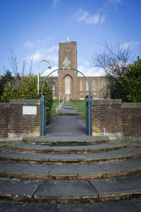 Footpath by building against sky