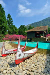 Deck chairs on shore against sky