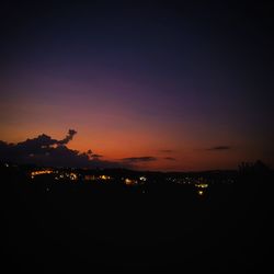 Illuminated cityscape against sky at night