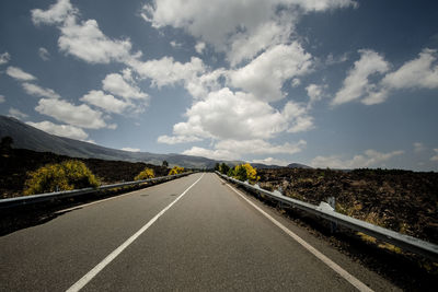 Empty road amidst mountain against sky