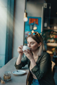 Young woman drinking coffee in cafe