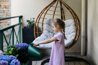 Portrait of young woman standing by railing