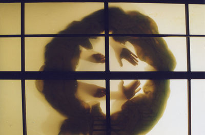 Shadow of man standing on window