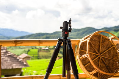 Close-up of camera on field against sky