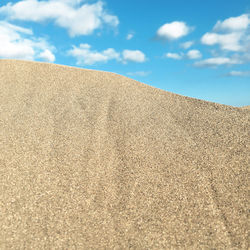Low angle view of sand on beach against sky