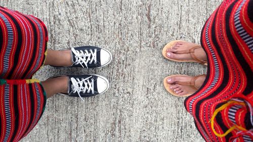 Low section of people in traditional costume standing on footpath